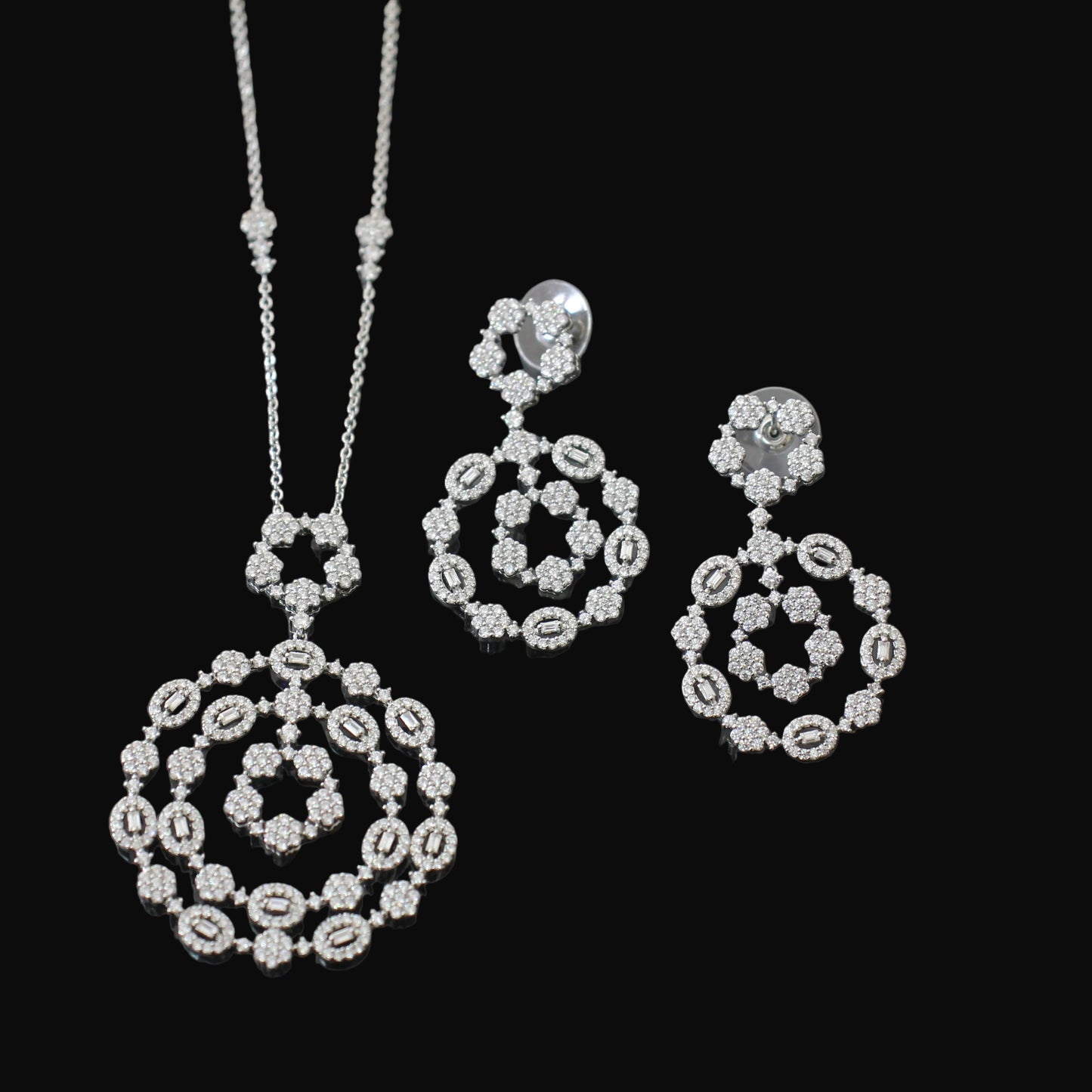 Silver jewelry set with necklace and earrings on a dark background