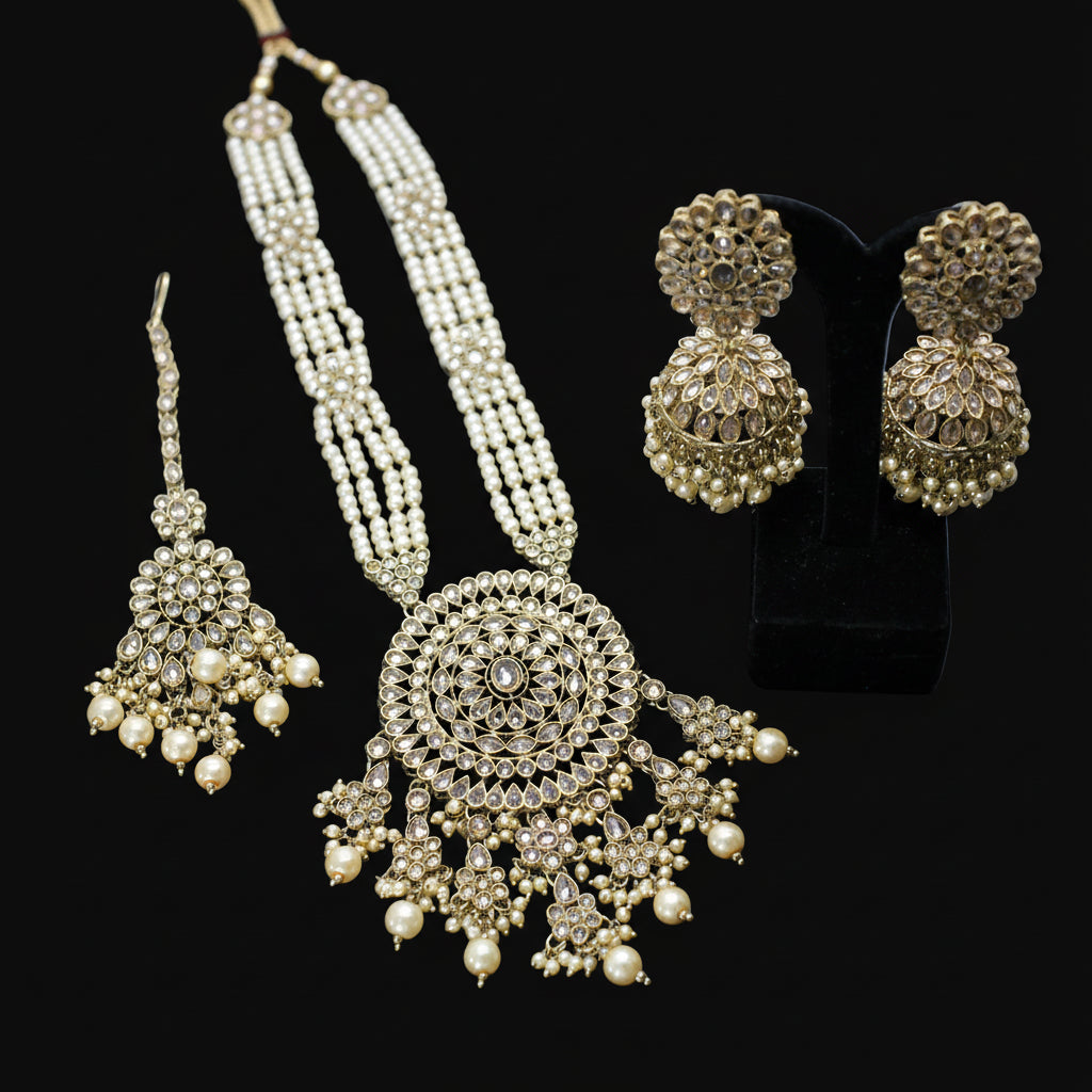 Ornate necklace and earrings on a dark background