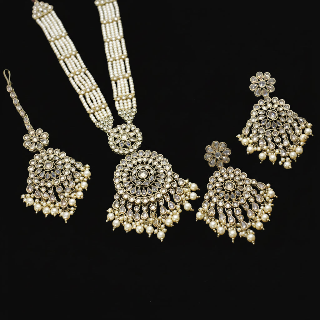 Set of silver jewelry including necklace, earrings, and rings on a dark background