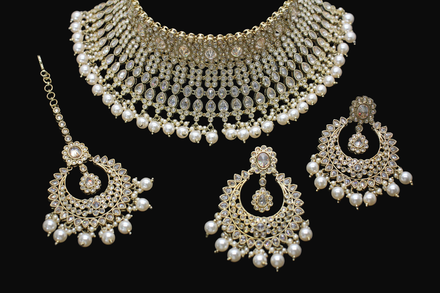 Gold and pearl jewelry set on a dark background