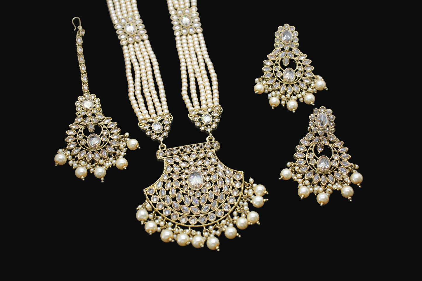 Gold and pearl jewelry set on a dark background
