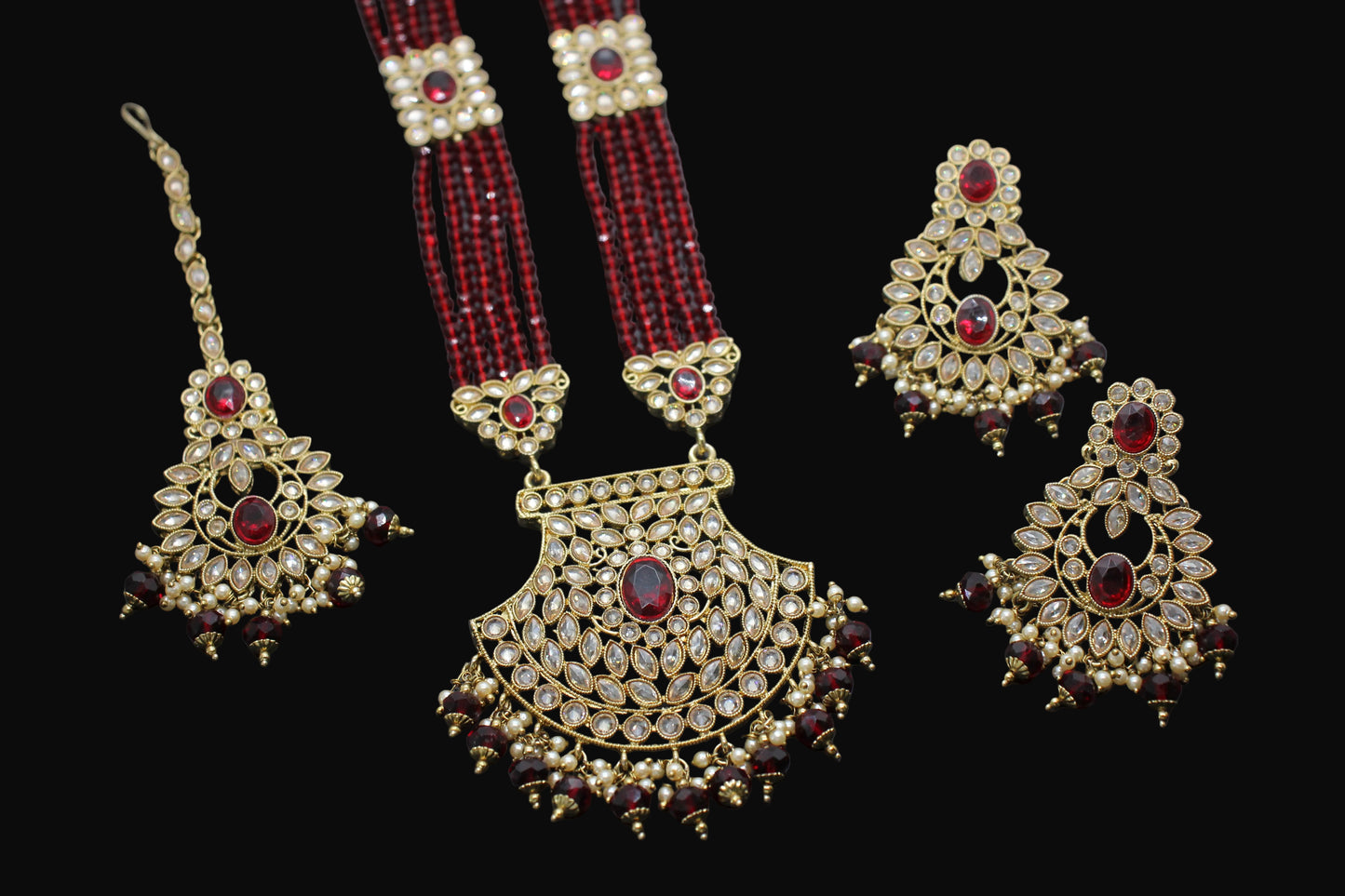 Set of gold and red jewelry on a dark background