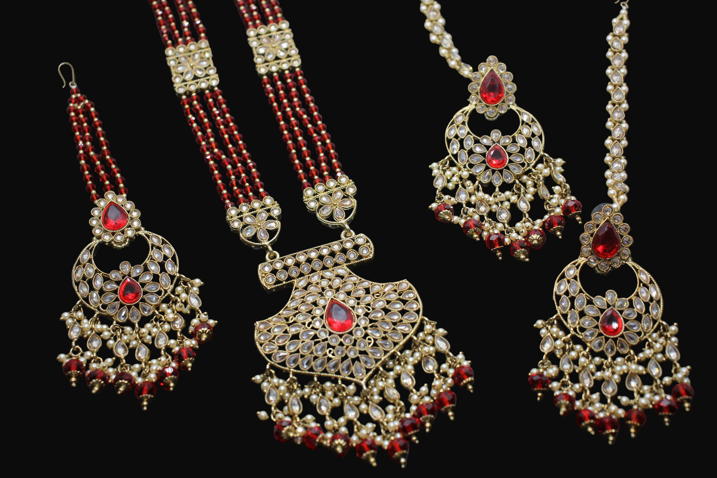 Ornate necklaces with red beads on a dark background