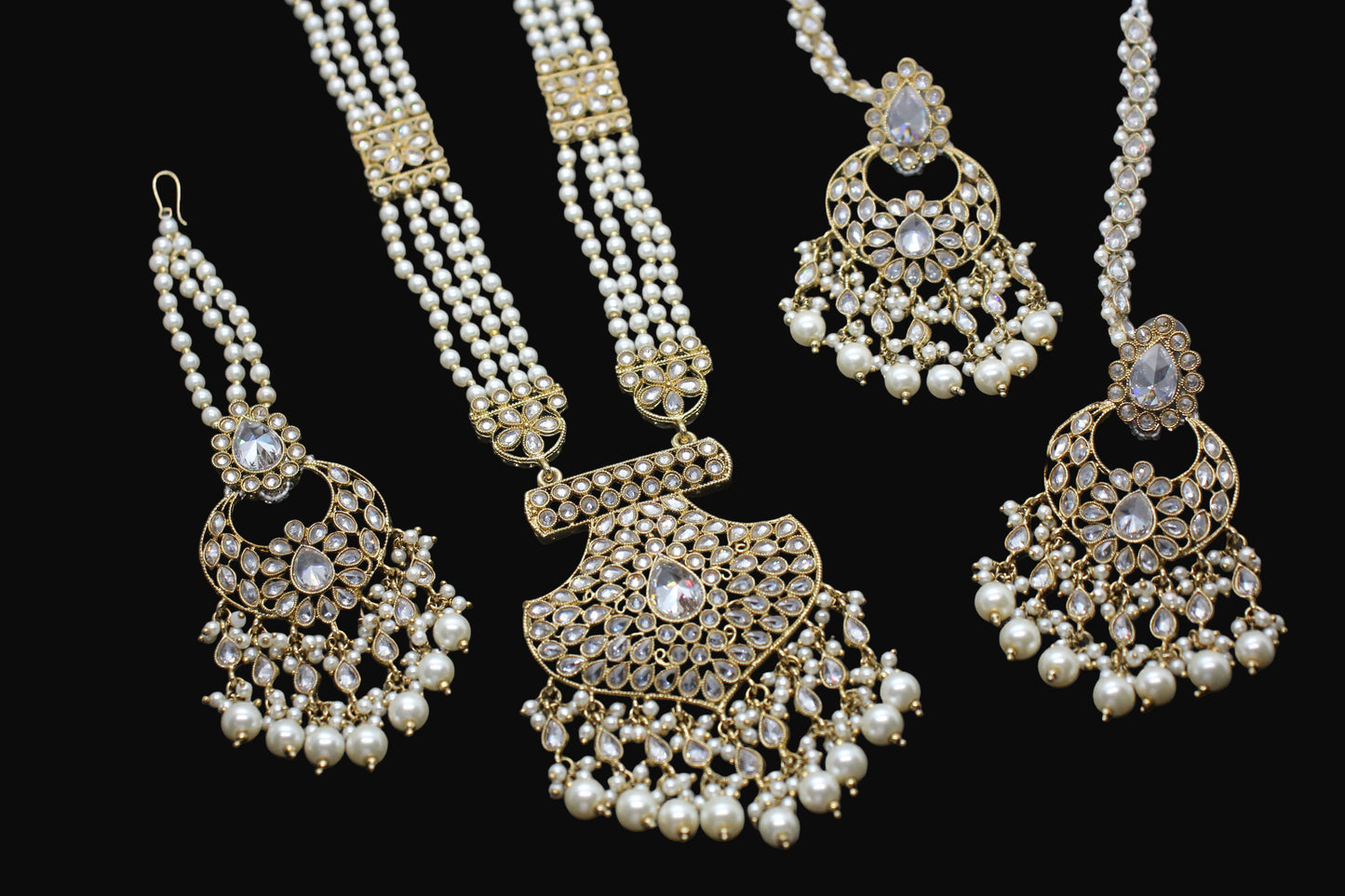 Gold and pearl jewelry set on a dark background