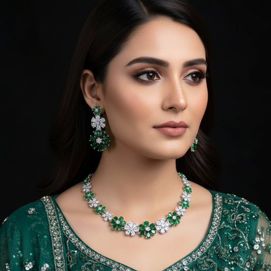 Jewelry set with necklace and earrings featuring green and white stones on a black background, branded 'Saheli'.