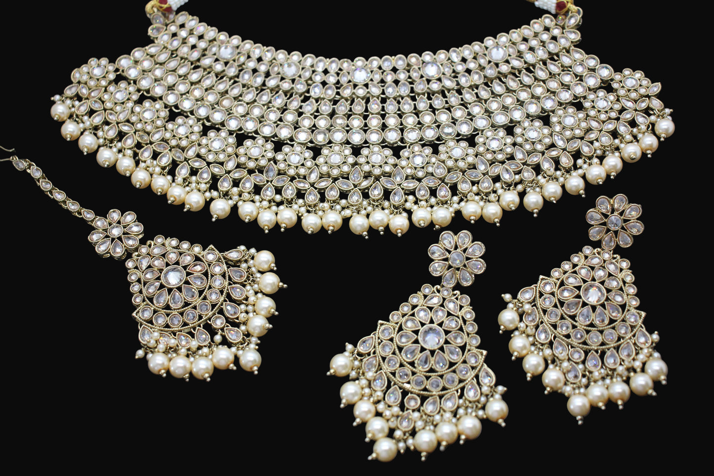 Pearl necklace and earrings set on a dark background