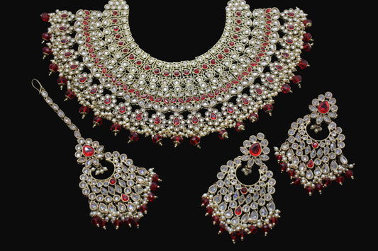 Ornate necklace set with red stones on a dark background