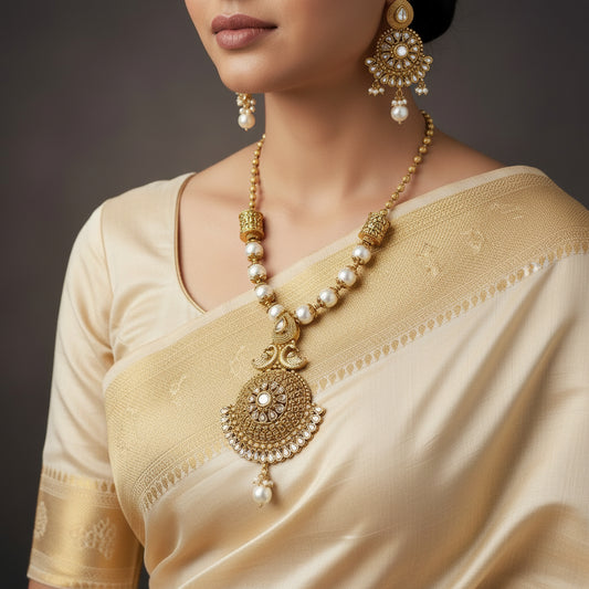 Gold necklace and earrings set with pearls on a dark background, branded 'Saheili'.