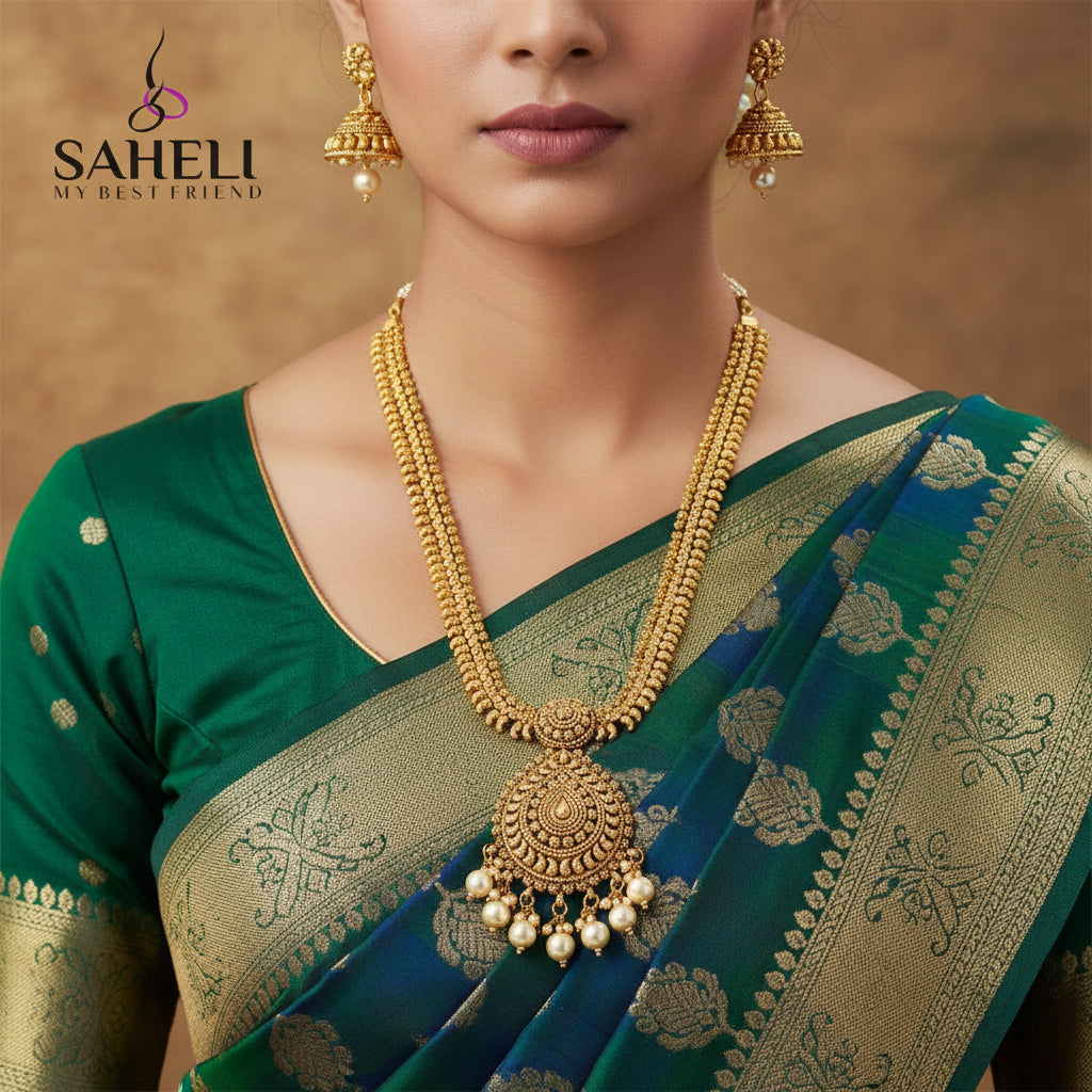 Gold necklace and earrings set with 'SAHELI' branding on a dark background