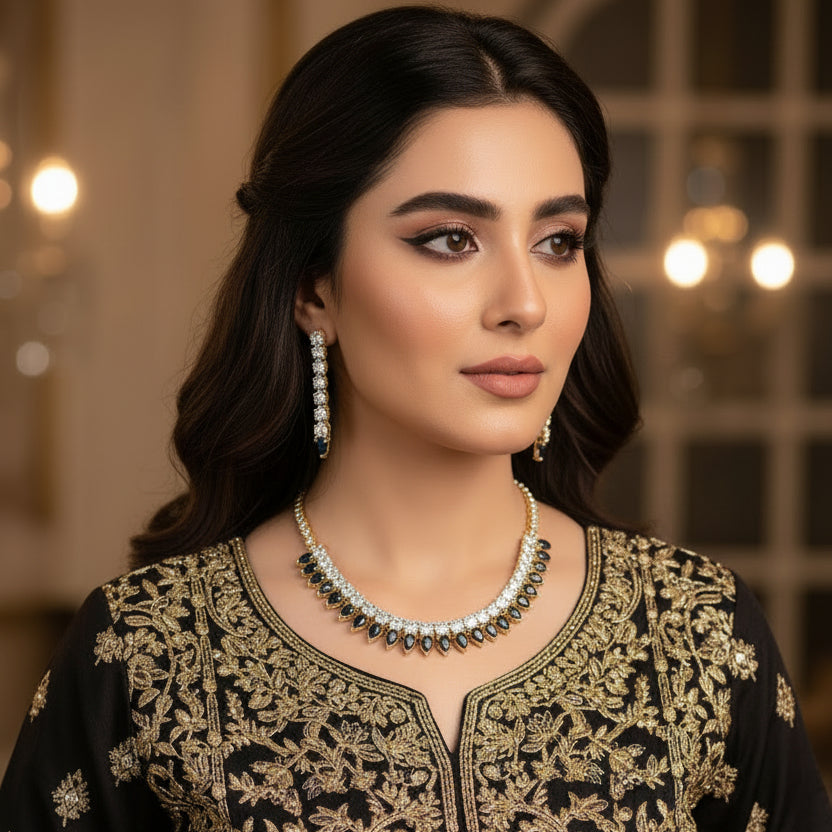 Gold and black necklace with matching earrings on a dark background, branded 'Saheli'.