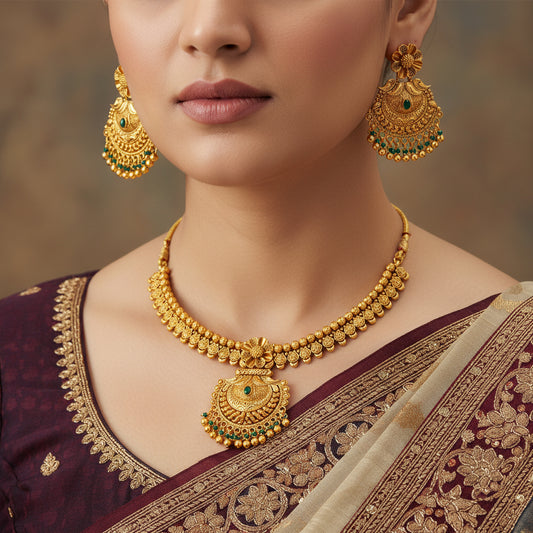 Gold necklace and earrings set on a green background