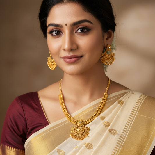 Gold necklace and earrings set on a green background