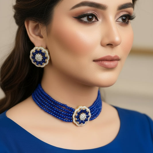 Blue beaded necklace with matching earrings on a dark surface
