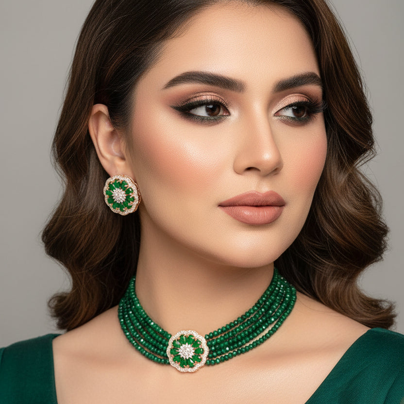 Green beaded necklace with floral earrings on a dark background