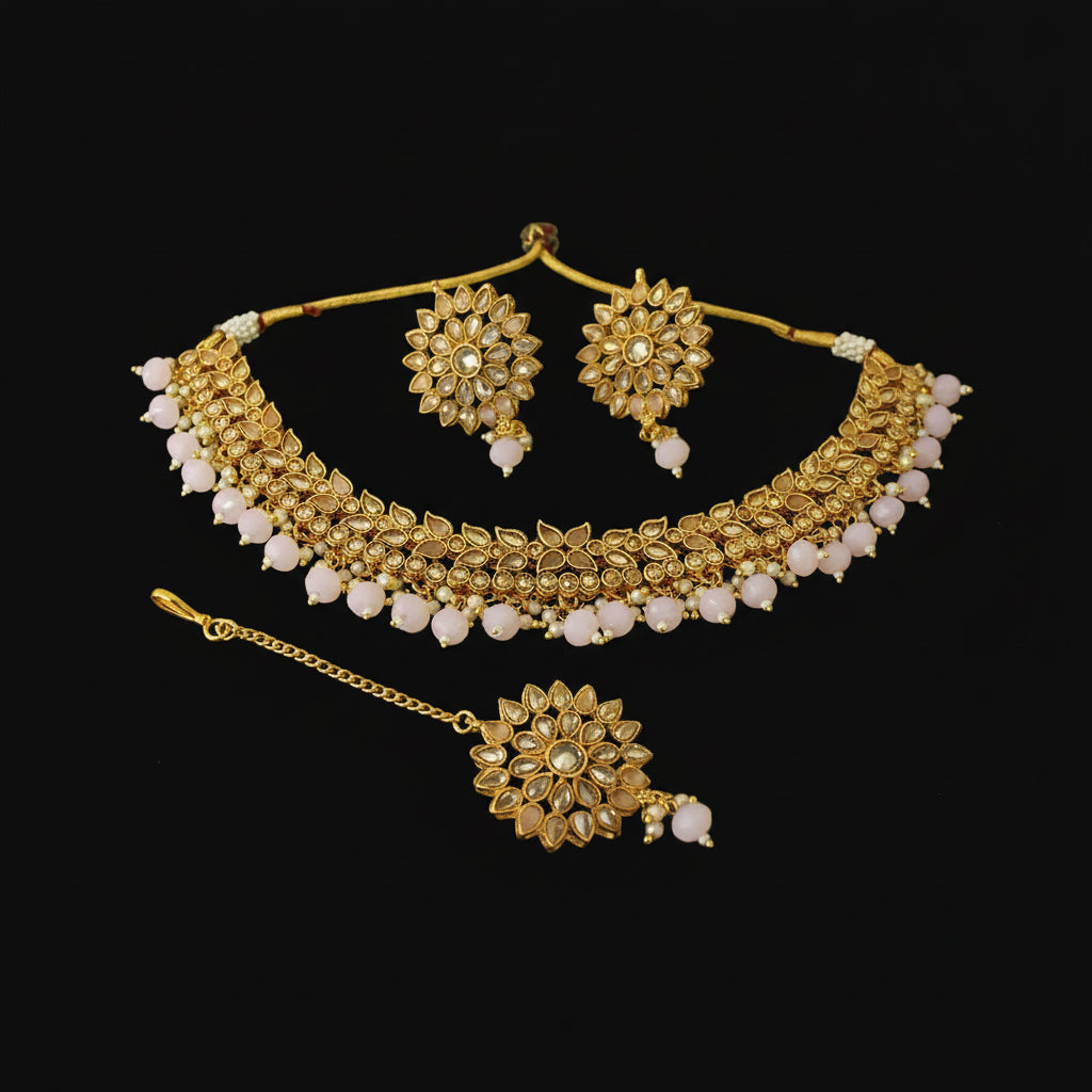 Gold necklace with matching earrings on a dark background