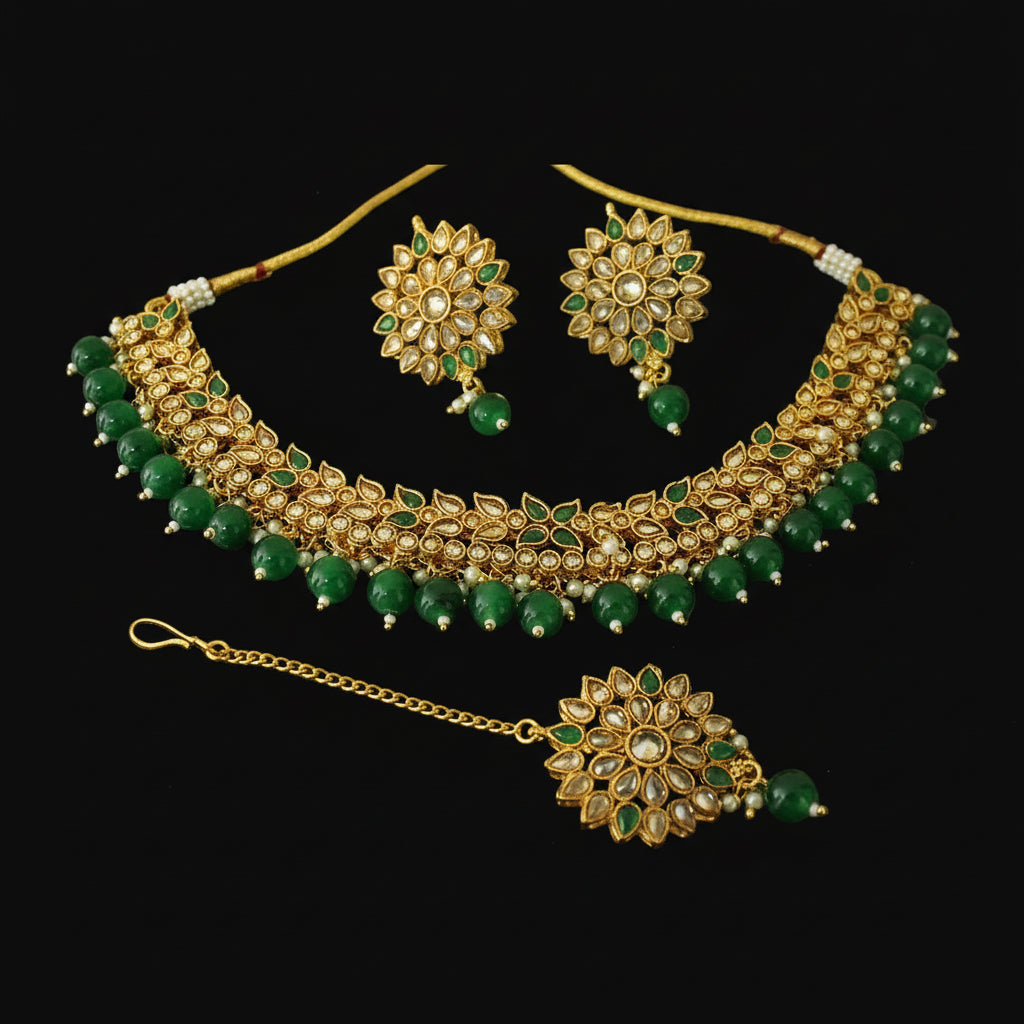 Gold and green jewelry set on a dark background