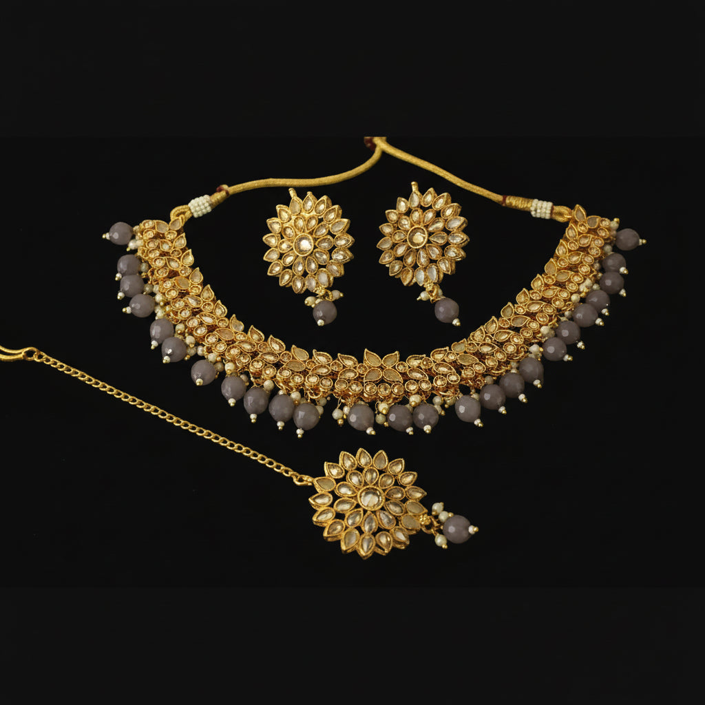 Gold necklace with purple beads and matching earrings on a black background