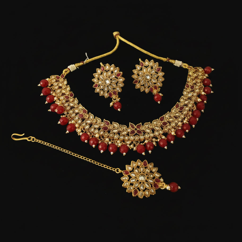 Gold and red jewelry set on a dark background