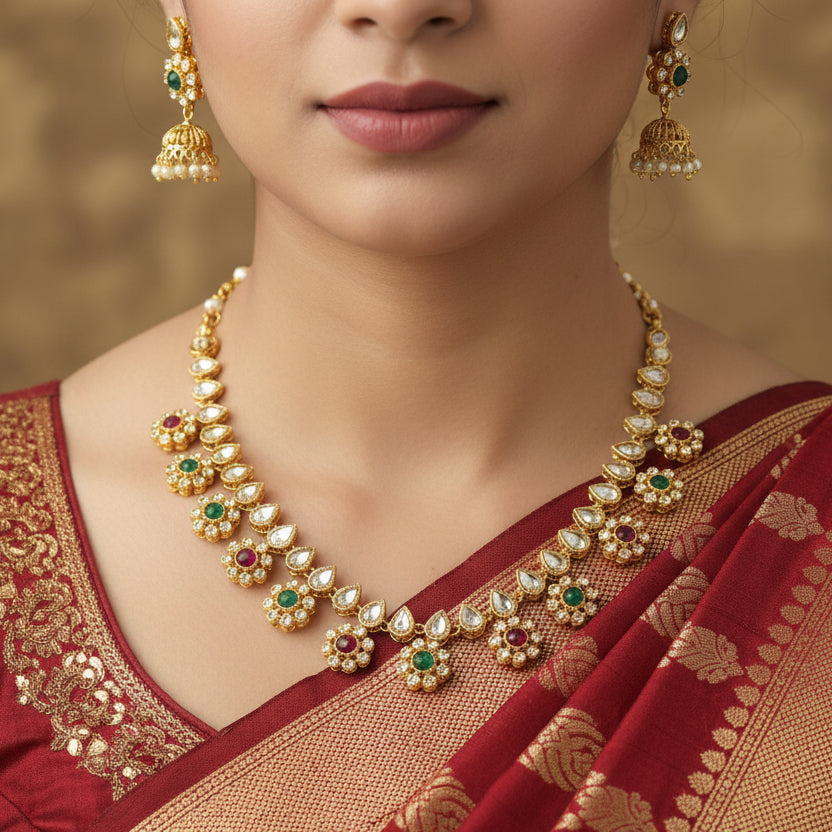 Gold necklace and earrings with gemstones on a black background