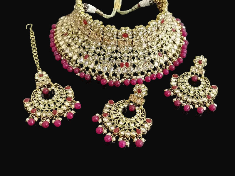 Jewelry set with necklace, earrings, and tikka on a dark background, branded 'SAHELI'.