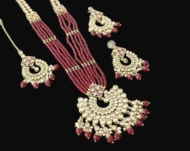 Jewelry set with necklace, earrings, and choker on a dark surface