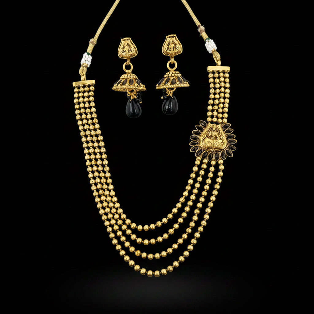 Gold-toned traditional Indian jewelry set featuring a multi-strand beaded necklace and matching dangle earrings with black teardrop stones, displayed on a black background. The brand logo 'SAHELL MY BEST FRIEND' is visible in the top right corner.