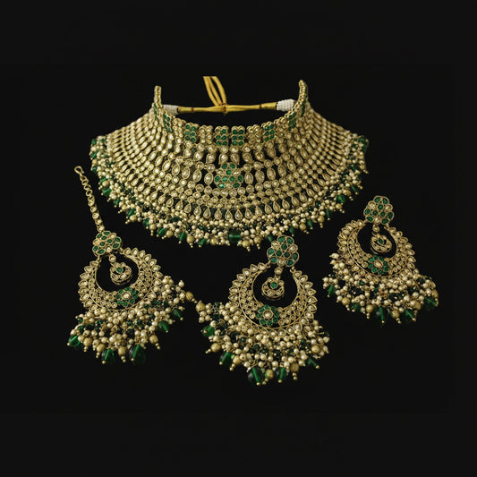 Gold and green jewelry set on a dark surface