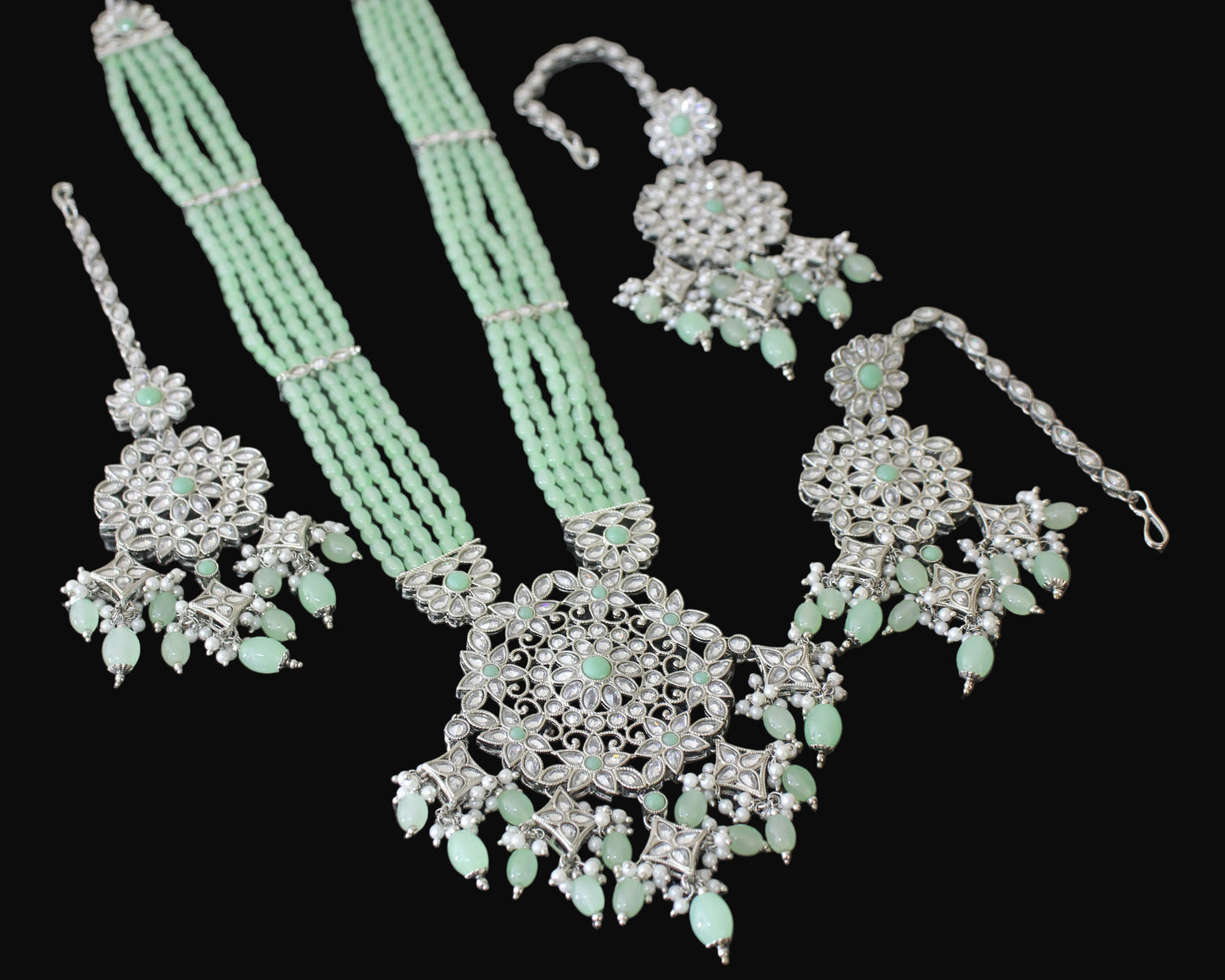 Jewelry set with necklace, earrings, and ring on a dark surface