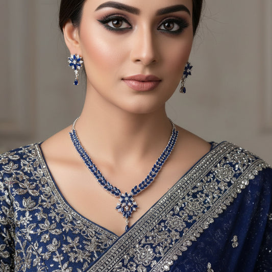 Jewelry set with necklace and earrings on a gray background, featuring the brand 'Saheli'.