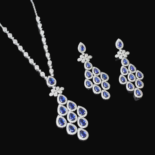 Silver necklace and earrings with blue stones on a black background