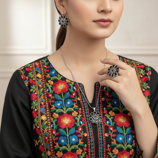Silver floral necklace and earrings on a reflective surface