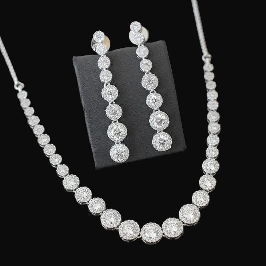Diamond necklace and earrings on a black stand against a dark background