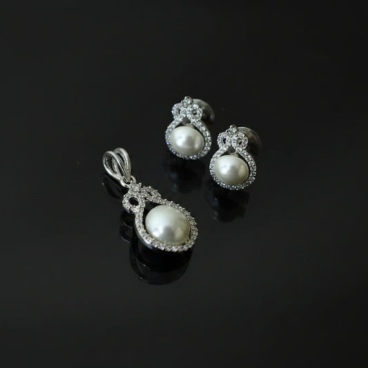 Pearl earrings with a 'Saheli' tag on a dark background