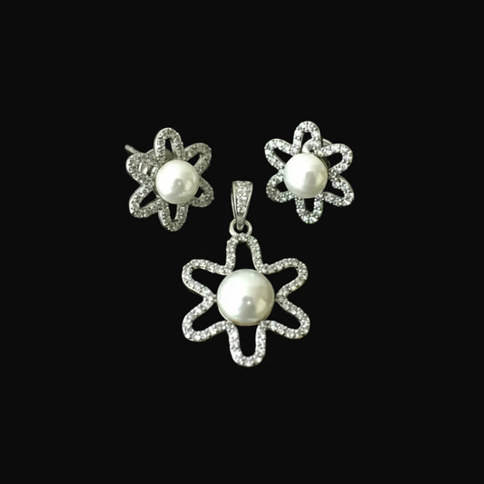 Pearl earrings with diamond accents on a black background, featuring the Saheli brand.