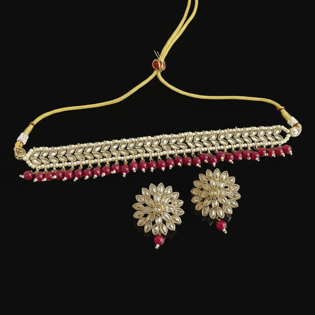 Gold and red jewelry set on a dark surface