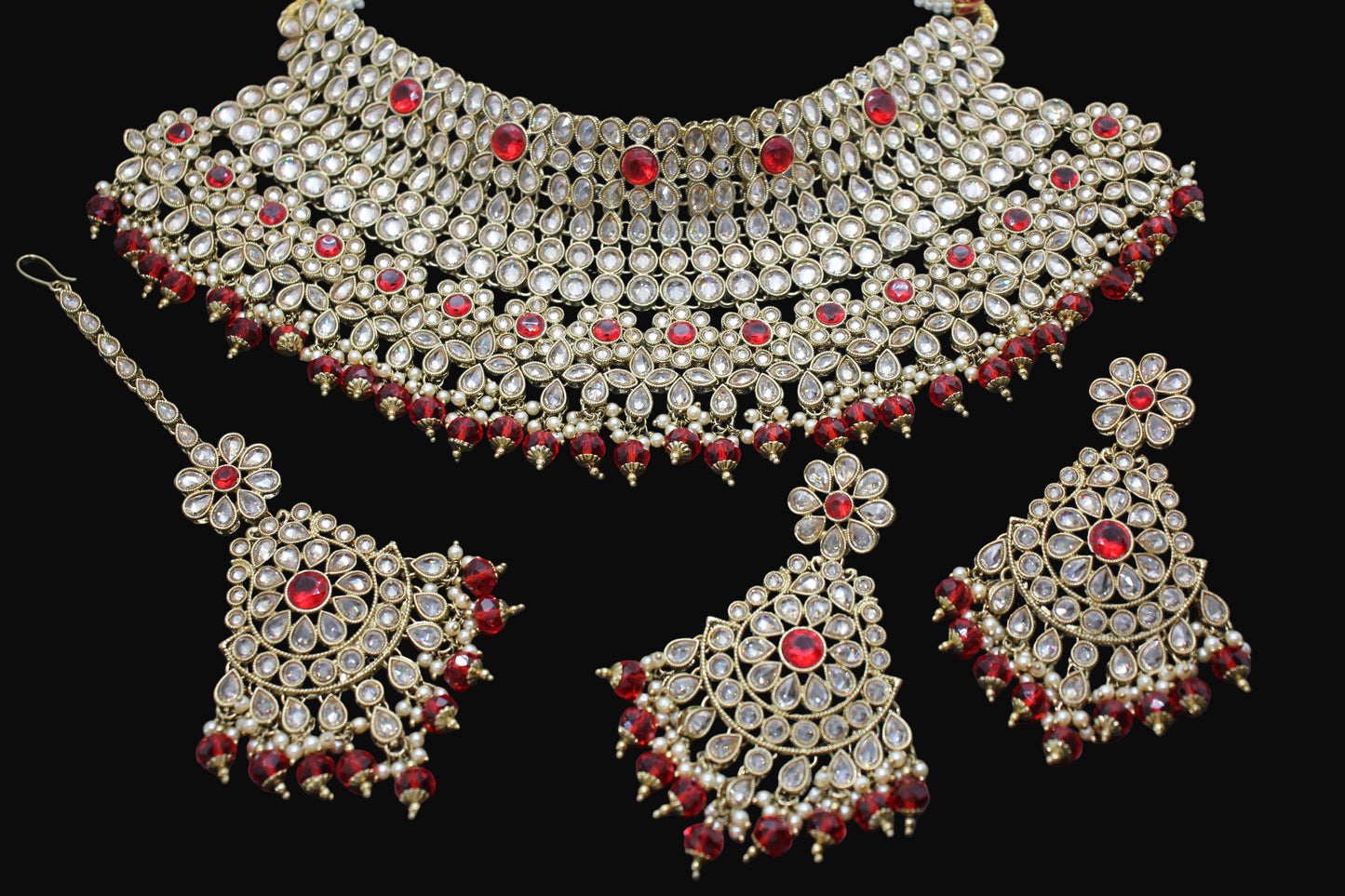 Ornate jewelry set with red stones on a dark background