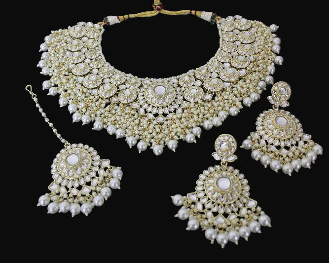 Pearl necklace and earrings set on a dark surface